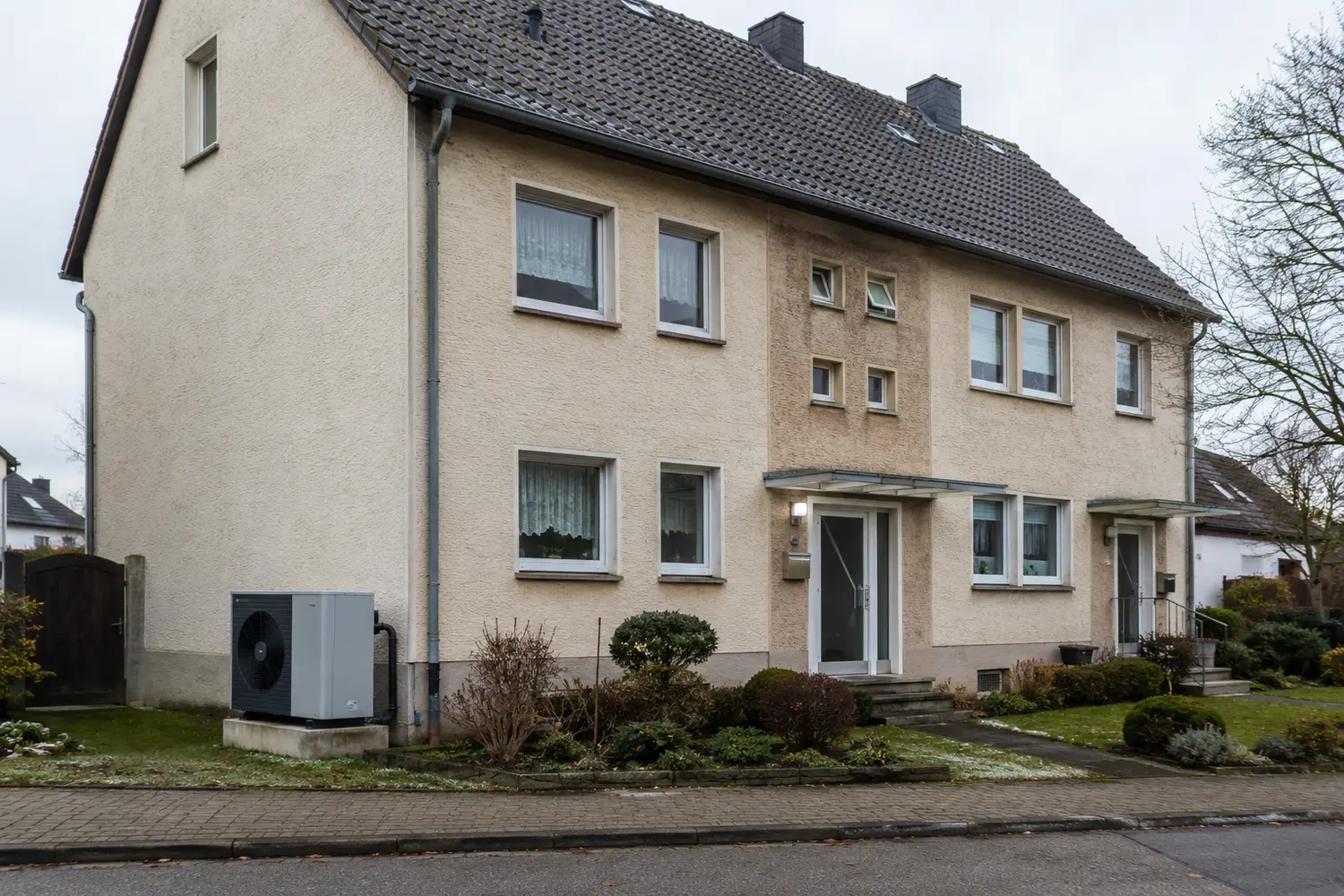 Wärmepumpe an einem älteren Zweifamilienhaus ohne vollständig gedämmte Fassade